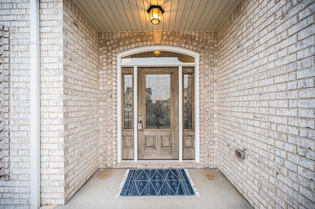 entrance to property featuring brick siding