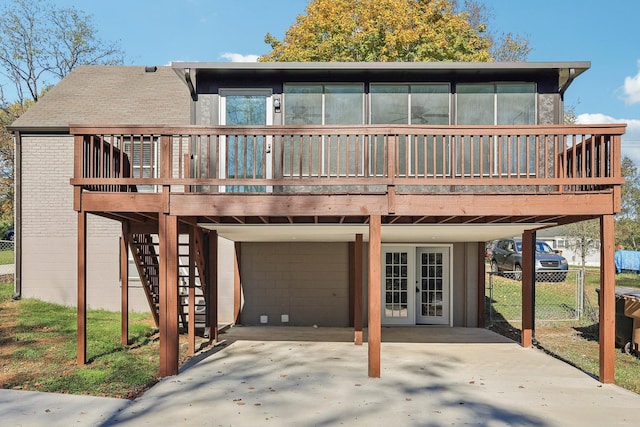 back of property featuring roof with shingles, stairs, fence, a carport, and brick siding