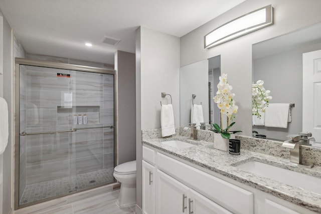 bathroom featuring a sink, toilet, and a shower stall