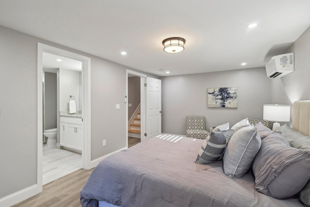 bedroom with baseboards, a wall mounted AC, recessed lighting, and light wood-style floors