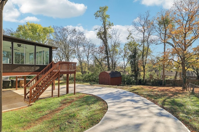 view of yard with an outbuilding, a patio, a storage shed, a sunroom, and stairs