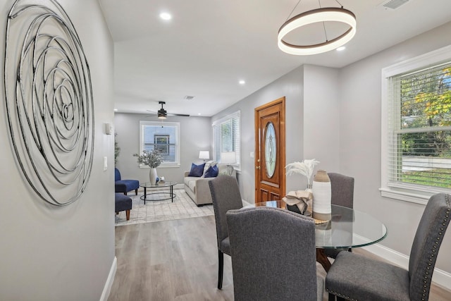 dining space with a ceiling fan, baseboards, wood finished floors, and recessed lighting