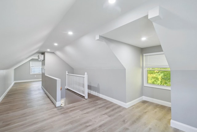 additional living space featuring vaulted ceiling, baseboards, and wood finished floors