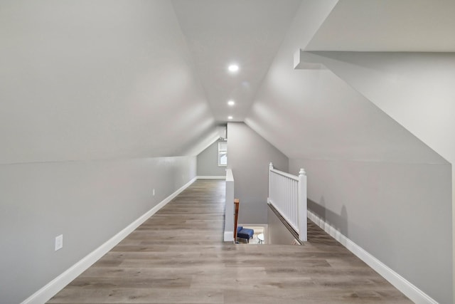 bonus room featuring vaulted ceiling, wood finished floors, and baseboards