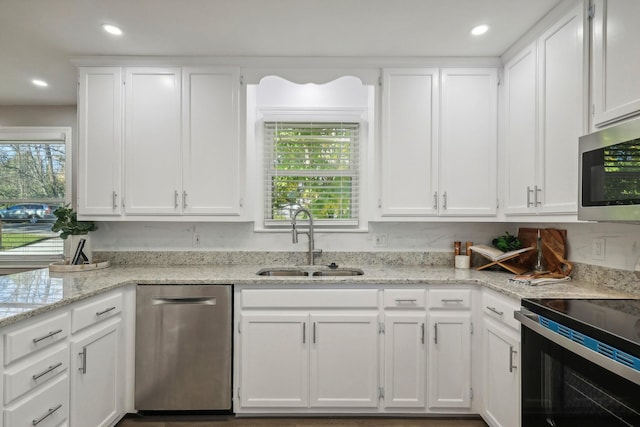 kitchen featuring appliances with stainless steel finishes, a sink, white cabinetry, and recessed lighting