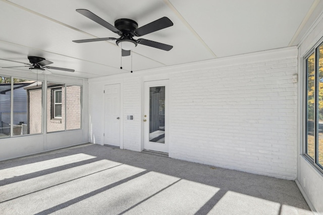 unfurnished sunroom featuring a ceiling fan