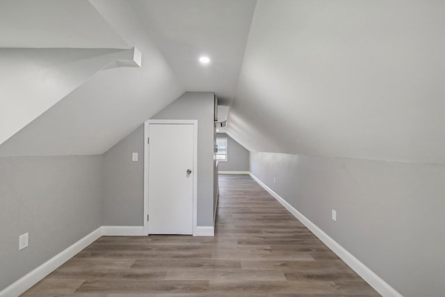 additional living space with vaulted ceiling, baseboards, and wood finished floors