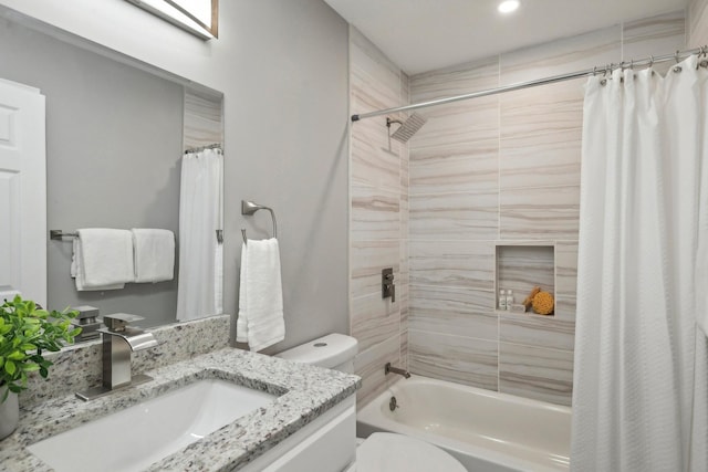 full bath featuring vanity, shower / bath combo with shower curtain, and toilet