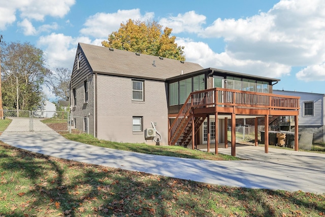 rear view of property with brick siding, a patio area, fence, a deck, and stairs