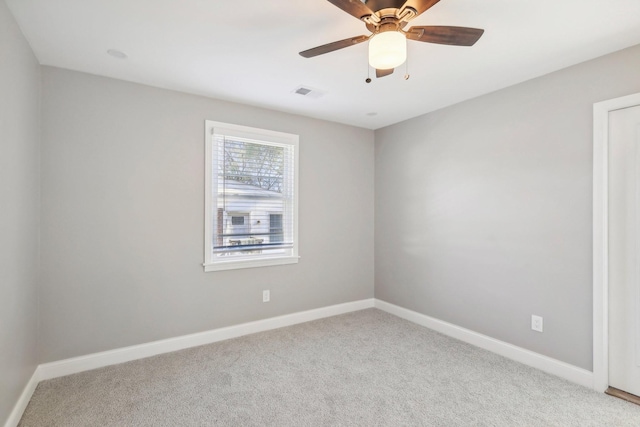 empty room featuring carpet, visible vents, ceiling fan, and baseboards