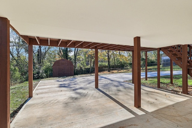 view of patio featuring fence, an outdoor structure, and a storage shed