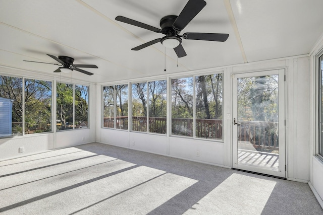 unfurnished sunroom featuring a ceiling fan and plenty of natural light