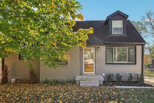 view of front of house featuring fence and brick siding