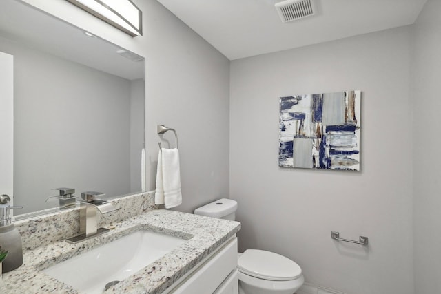 bathroom featuring visible vents, vanity, and toilet