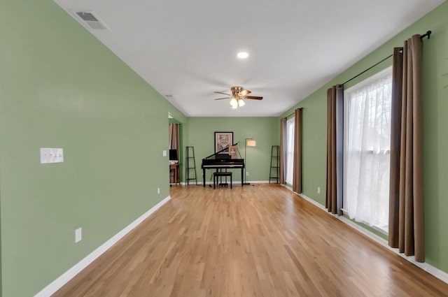 empty room featuring ceiling fan, light wood-type flooring, visible vents, and baseboards