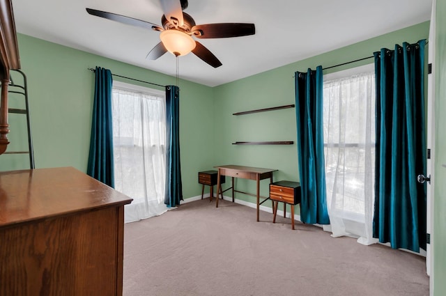 office area with a ceiling fan, a wealth of natural light, carpet flooring, and baseboards