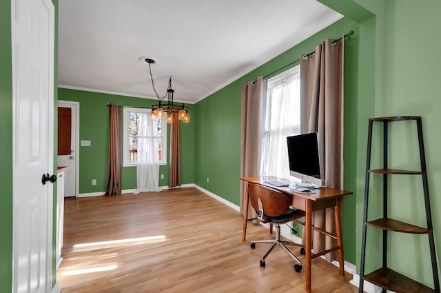 office space featuring a healthy amount of sunlight, light wood finished floors, baseboards, and crown molding