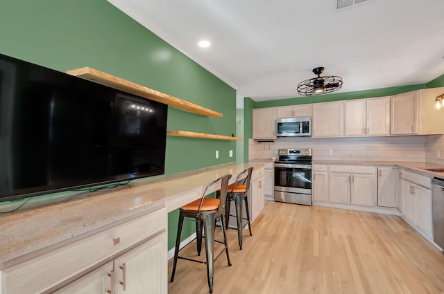 kitchen featuring tasteful backsplash, appliances with stainless steel finishes, ornamental molding, light wood-style floors, and open shelves