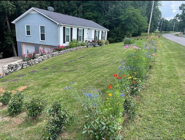 view of front of house with a garage and a front lawn