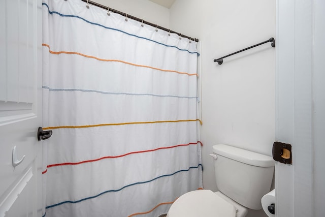 bathroom featuring a shower with curtain and toilet