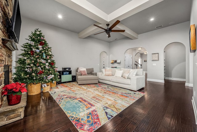 living room with arched walkways, wood finished floors, visible vents, and a ceiling fan