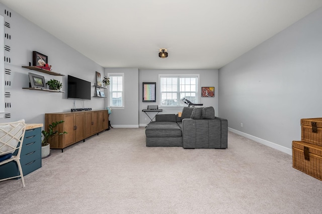 living area featuring light carpet and baseboards