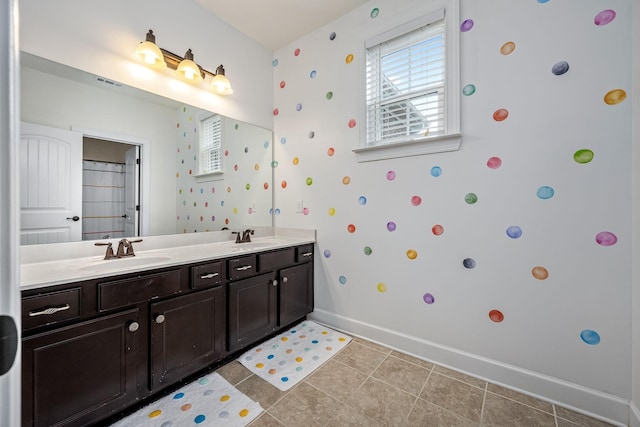 full bathroom with double vanity, visible vents, a sink, baseboards, and tile patterned floors