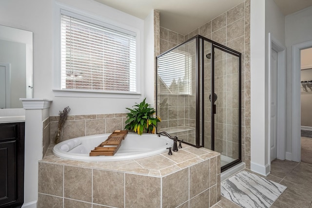 bathroom with a stall shower, tile patterned flooring, a garden tub, and a walk in closet