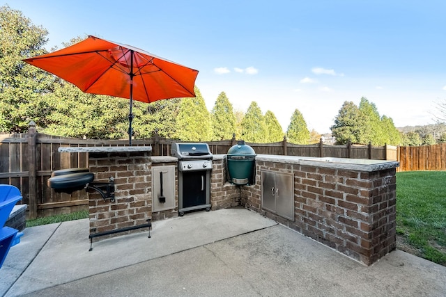 view of patio / terrace featuring outdoor dry bar, grilling area, an outdoor kitchen, and a fenced backyard