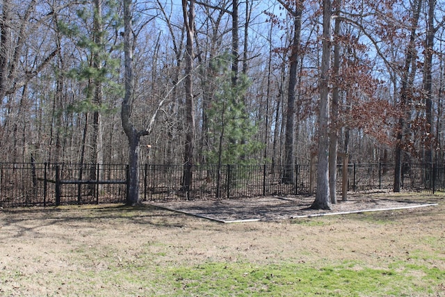 view of yard with fence and a wooded view