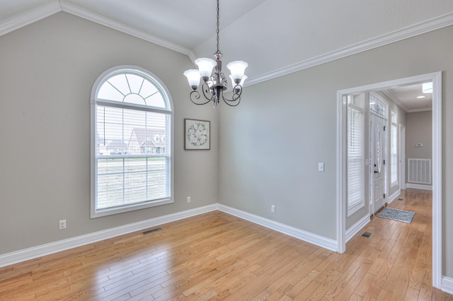 unfurnished room with light wood-type flooring, visible vents, a notable chandelier, and ornamental molding