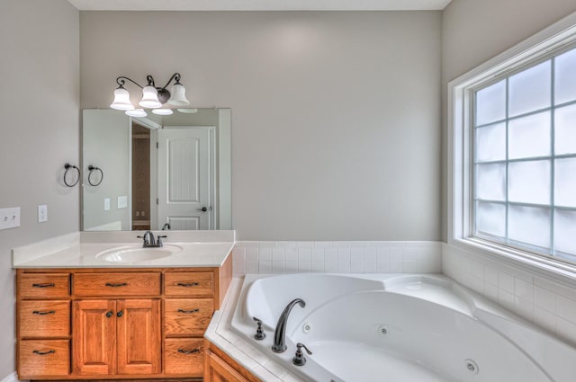 full bathroom featuring a tub with jets and vanity