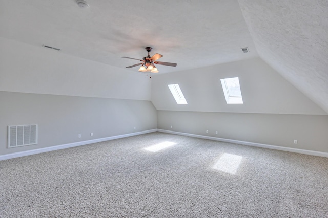 bonus room with lofted ceiling with skylight, baseboards, and visible vents
