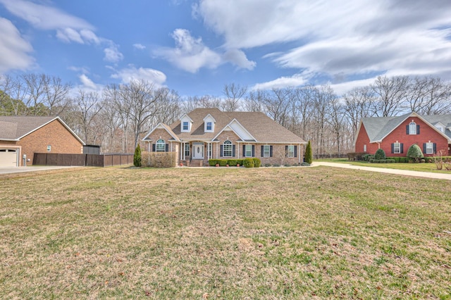 view of front of property with brick siding, a front yard, and fence