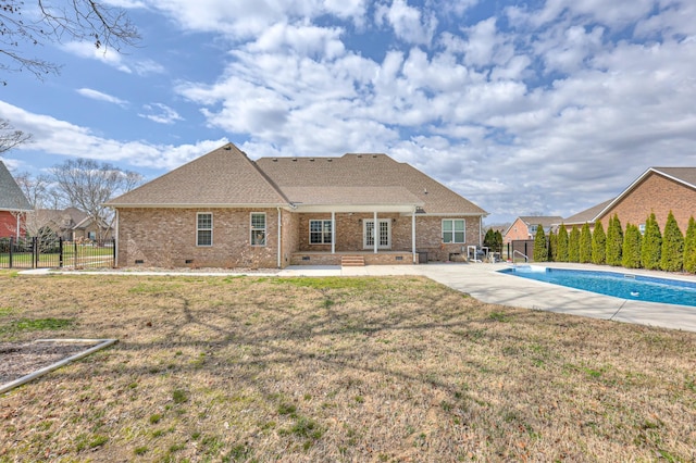 back of property with a patio, fence, a yard, crawl space, and brick siding
