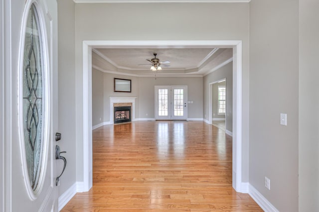 entrance foyer featuring ornamental molding, light wood-style floors, baseboards, and ceiling fan