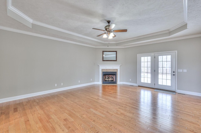 unfurnished living room featuring baseboards, light wood-style floors, ceiling fan, and a textured ceiling