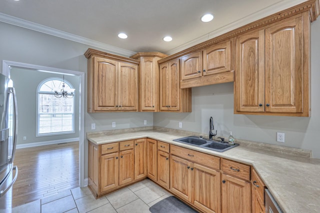 kitchen featuring recessed lighting, a sink, light countertops, crown molding, and a chandelier
