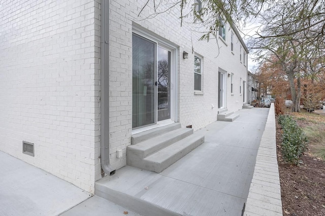 view of side of home featuring entry steps and brick siding