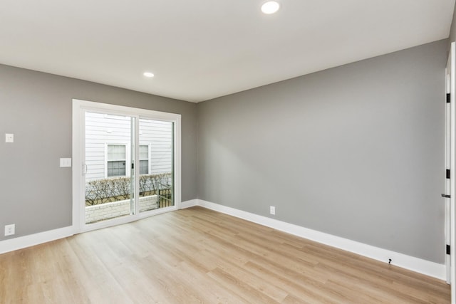 spare room featuring light wood-style floors, baseboards, and recessed lighting