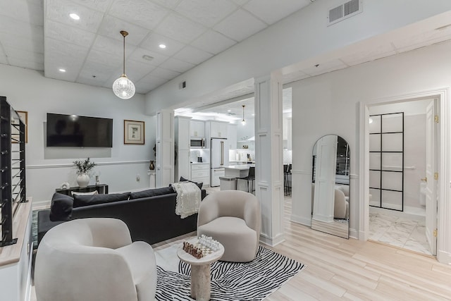 living room featuring visible vents, light wood-style floors, a paneled ceiling, and recessed lighting