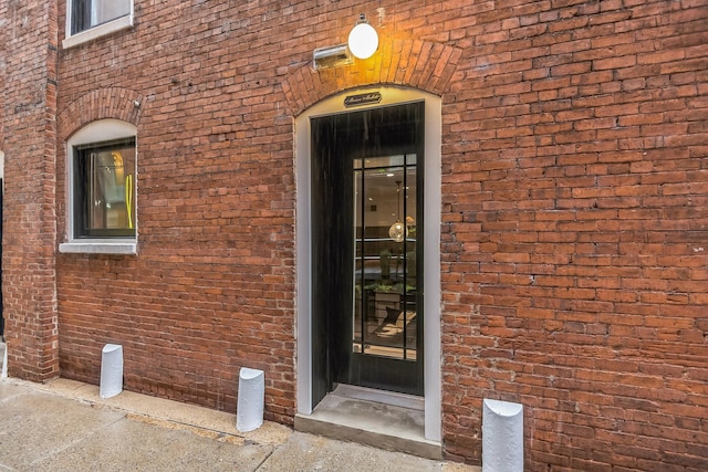 doorway to property with brick siding