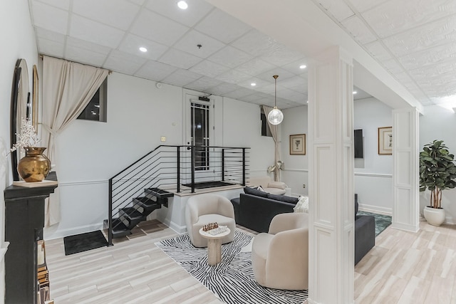 living room with stairs, recessed lighting, wood finished floors, and baseboards