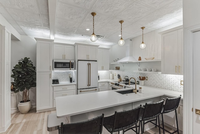 kitchen featuring an ornate ceiling, a breakfast bar area, open shelves, high quality appliances, and a peninsula