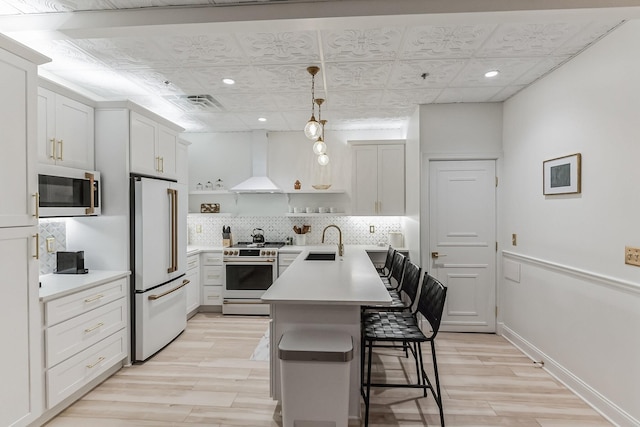 kitchen with wall chimney exhaust hood, stainless steel appliances, a kitchen bar, open shelves, and a sink