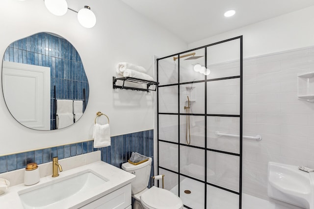 bathroom with toilet, a wainscoted wall, vanity, a walk in shower, and recessed lighting