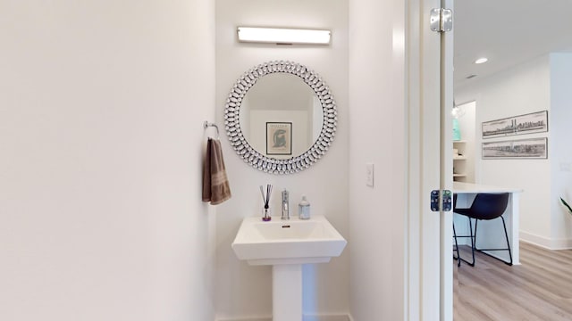 bathroom with recessed lighting, baseboards, and wood finished floors