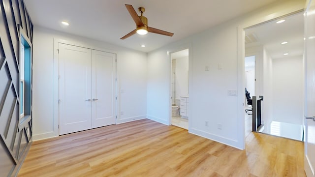 unfurnished bedroom with recessed lighting, baseboards, a closet, light wood-type flooring, and ensuite bath