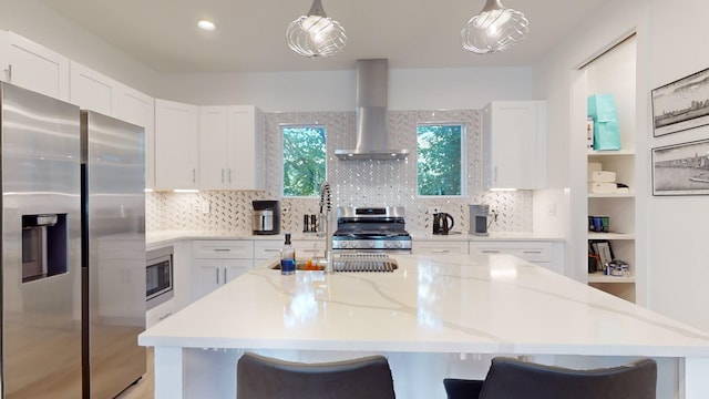 kitchen with stainless steel appliances, white cabinetry, wall chimney range hood, and tasteful backsplash