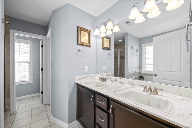 full bathroom featuring tile patterned flooring, a sink, visible vents, and a shower stall